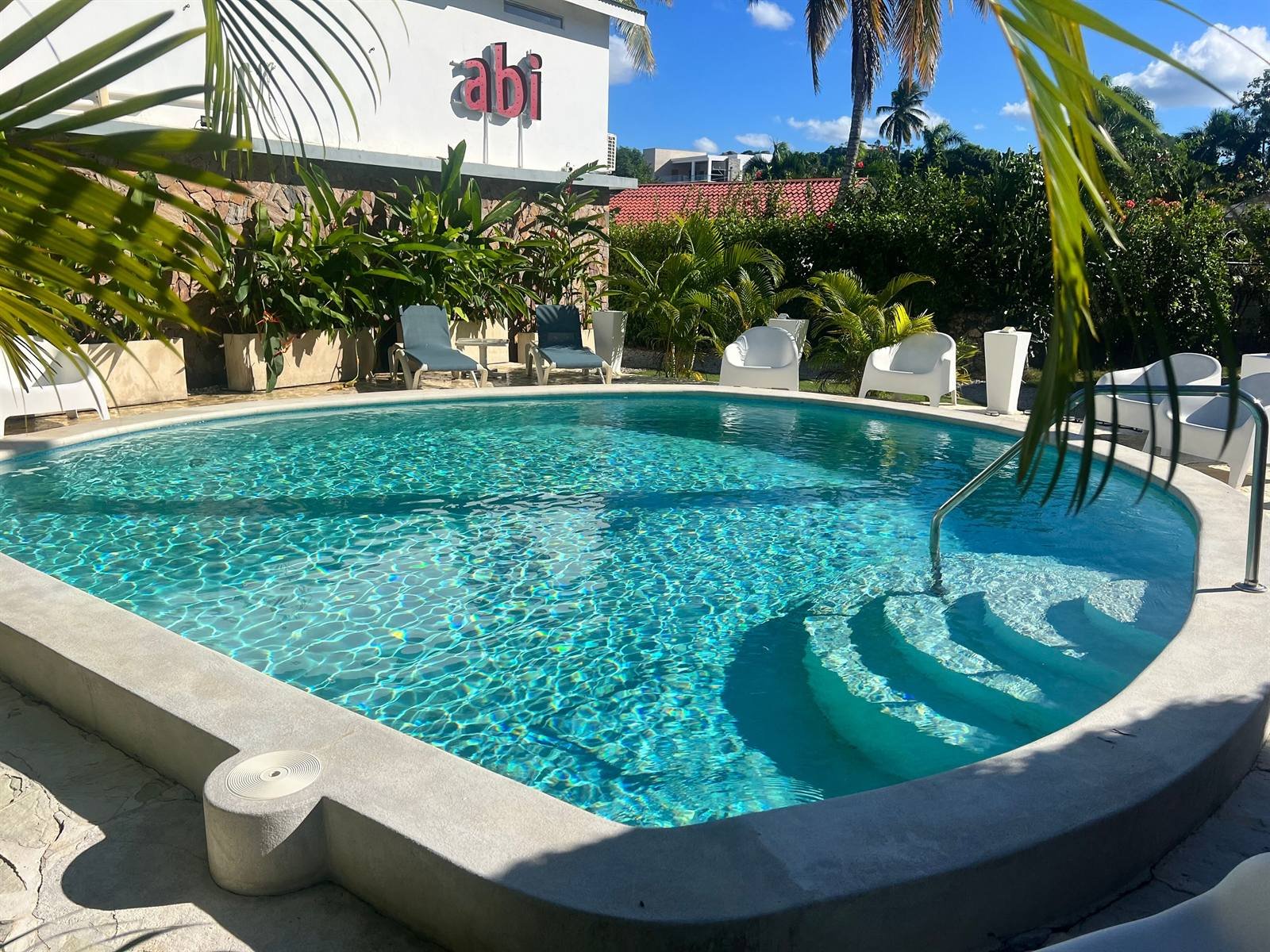 El Rincón de Abi: the pool surrounded by white loungers and tropical plants