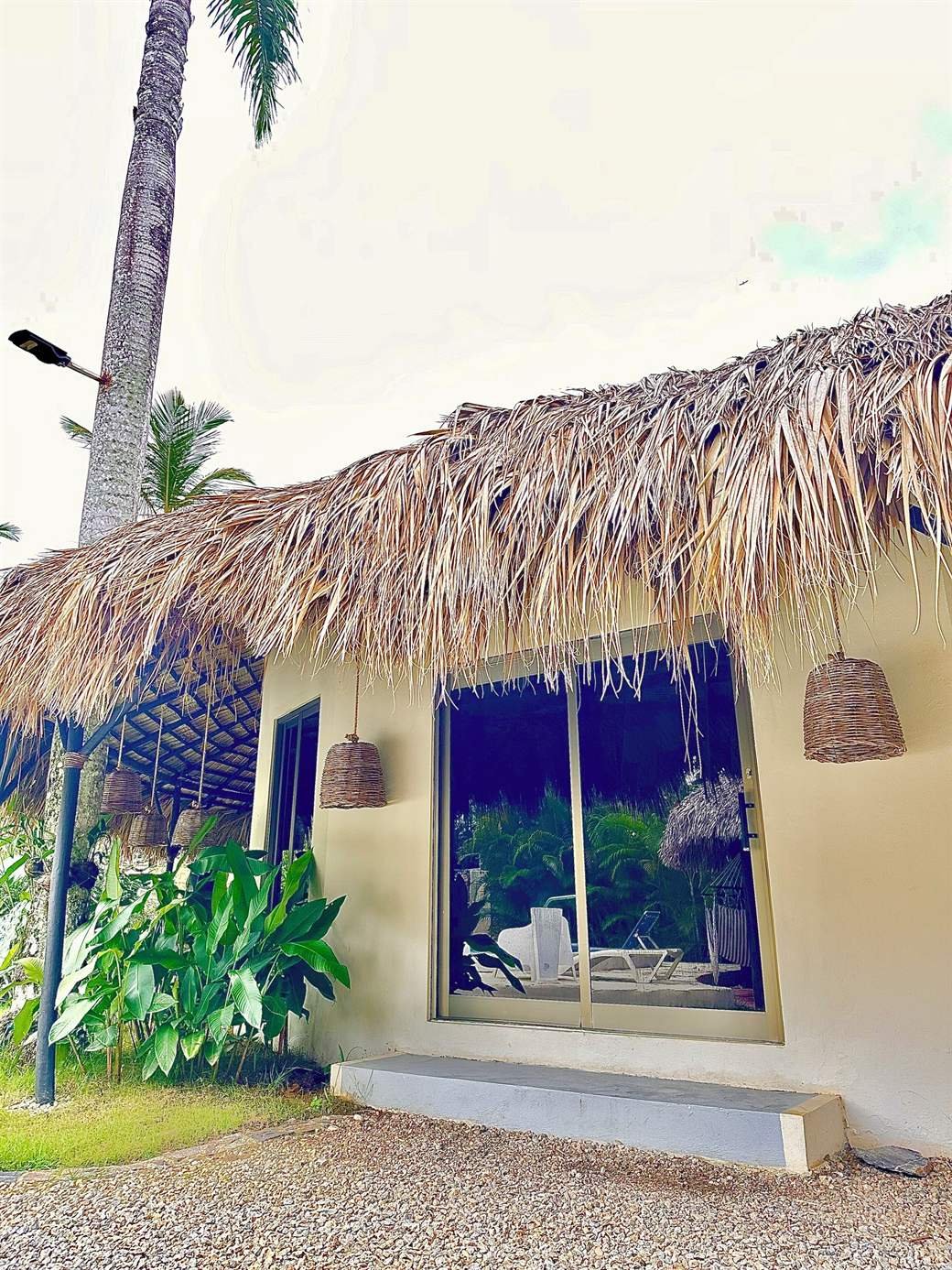 El Rincón de Abi: ground-floor room with a thatched roof and a big window onto the garden